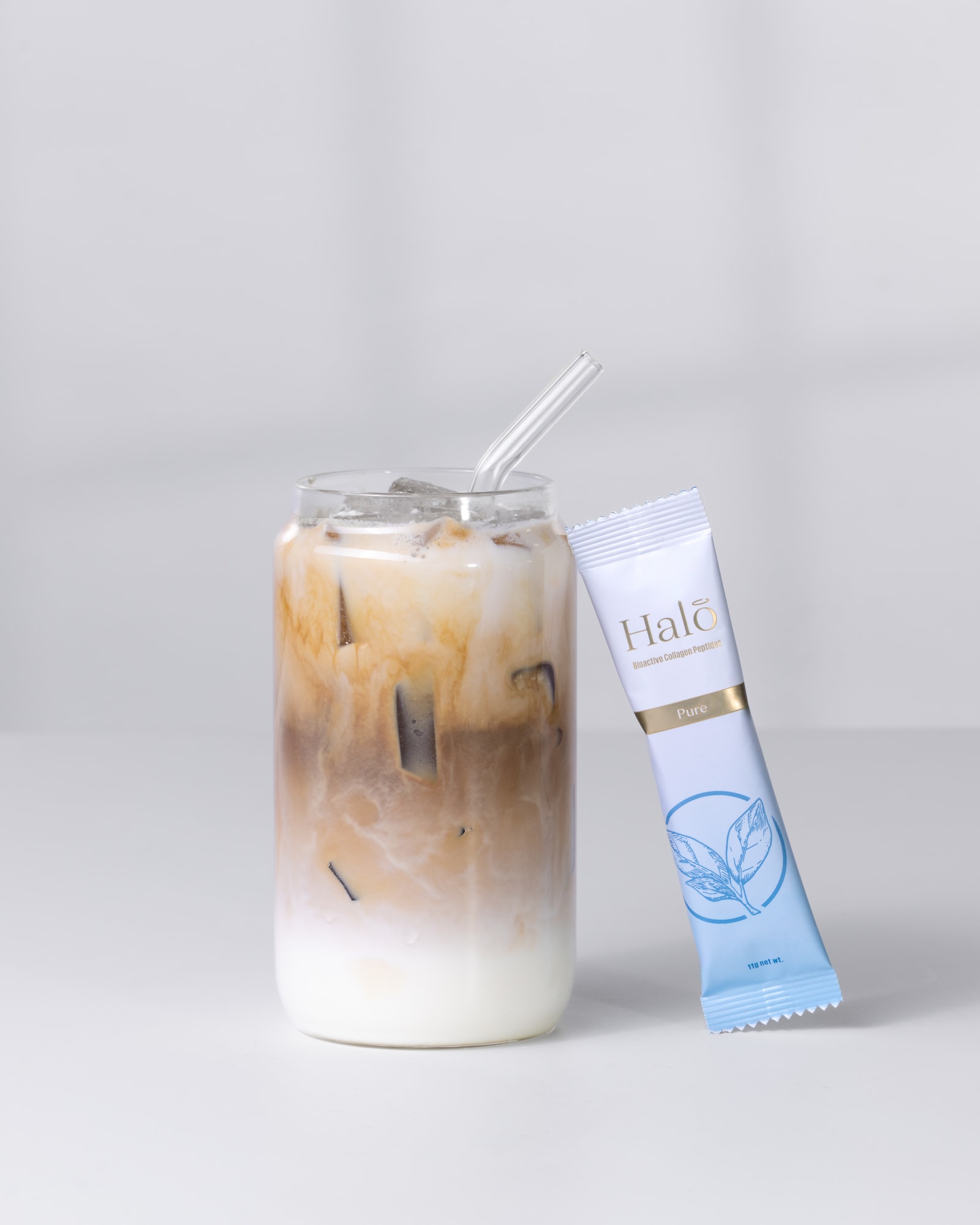 A Halo 100% Pure sachet beside an iced latte