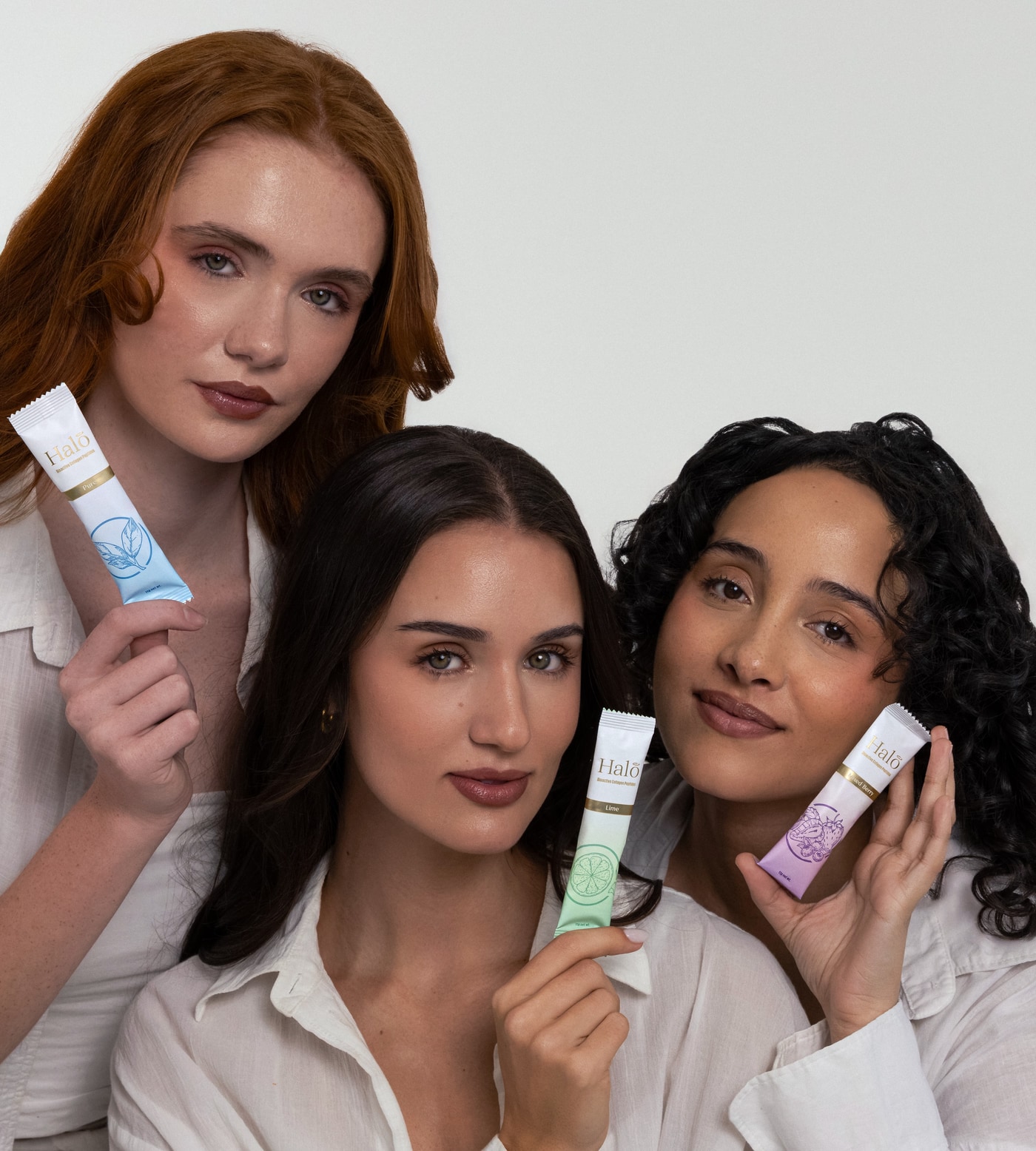 Three women holding Halo sachets in 100% Pure, Lime and Mixed Berry